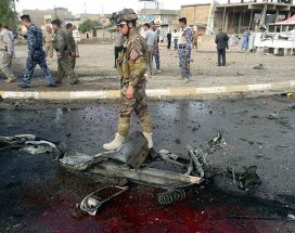 Иракский солдат проходит мимо обломков автомобиля